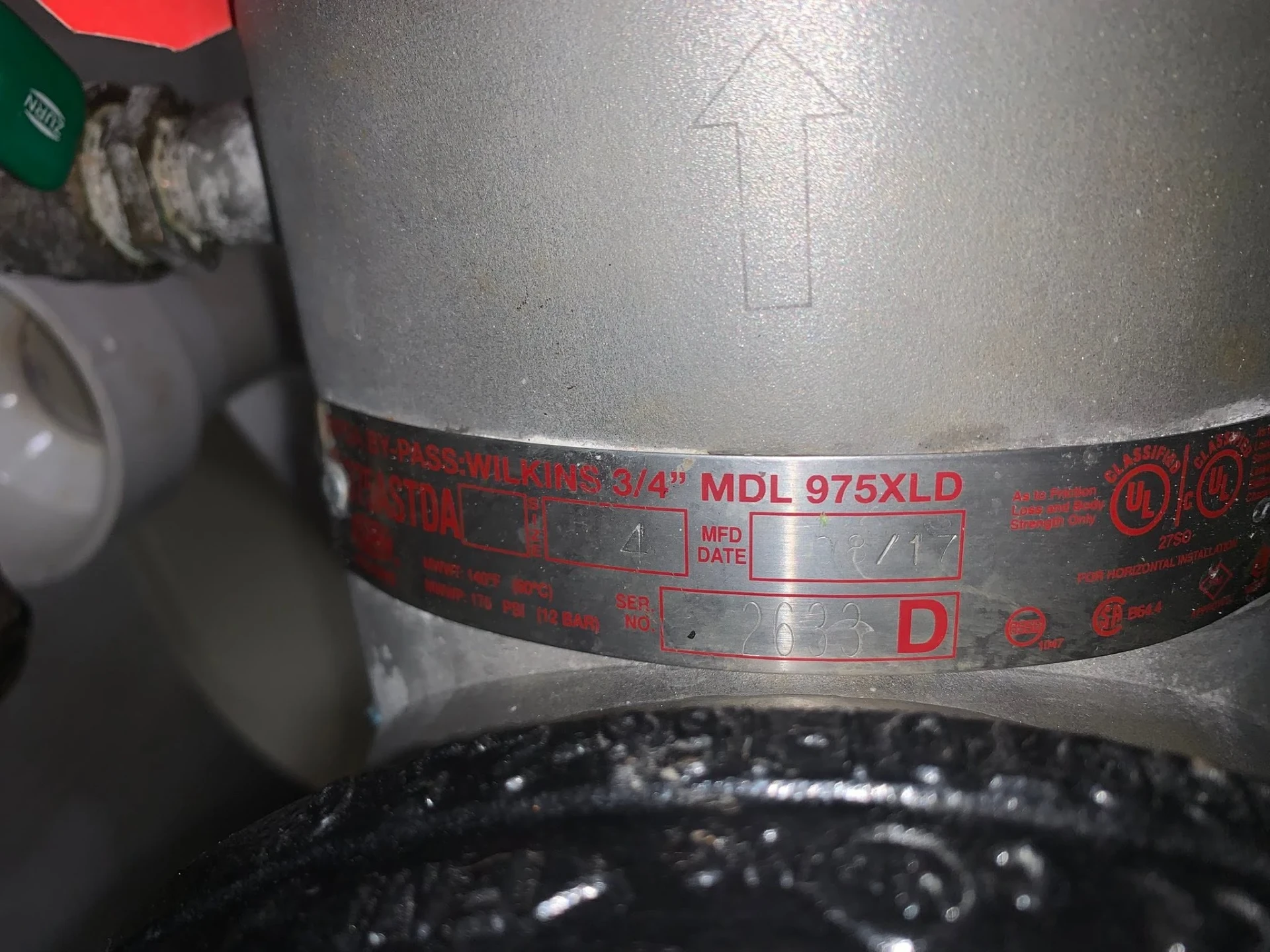 Wilkins 975XLD three quarter inch backflow preventer nameplate showing model, serial number, and manufacture date