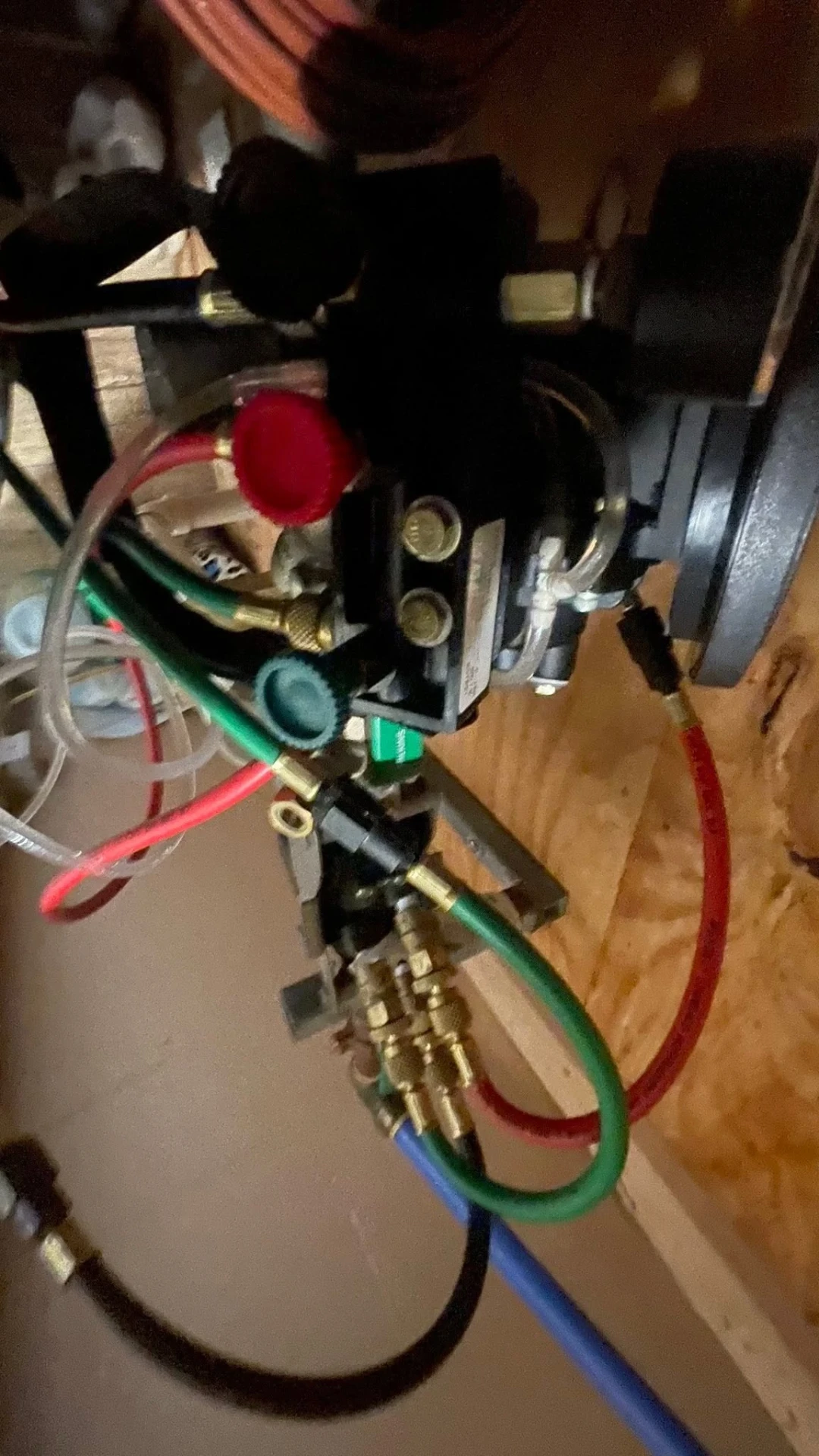 Backflow test kit hoses in red, green, and black connected to test cocks on a valve assembly