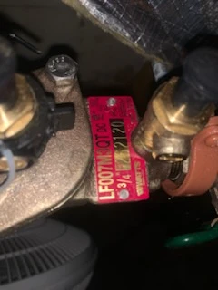 Red Watts LF007M1 three quarter inch backflow preventer tag between two brass test cocks