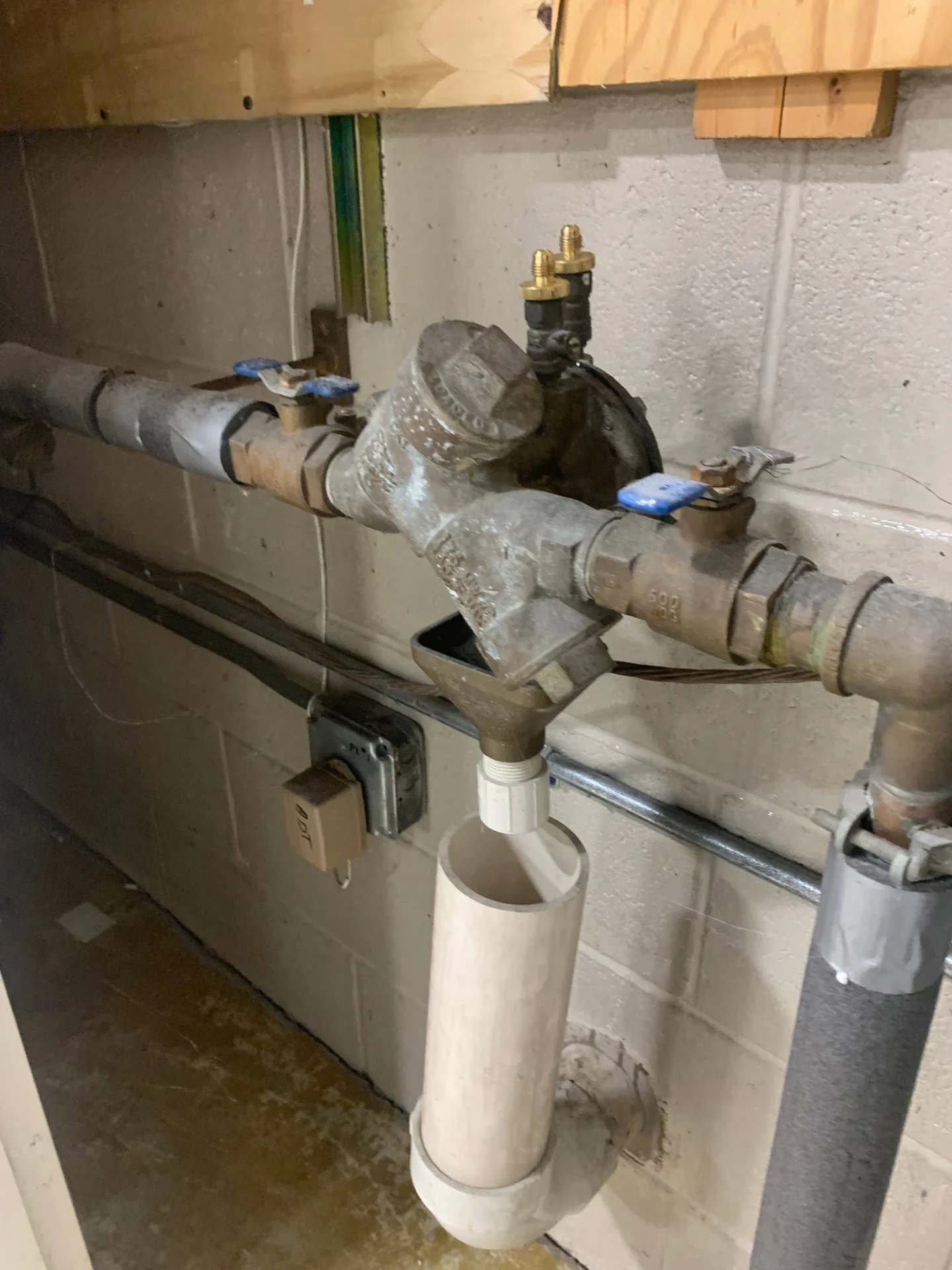 Full reduced pressure zone backflow assembly installed on copper pipe with a PVC air gap drain in a basement