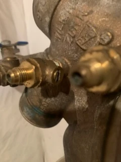Brass Wilkins backflow preventer body with two test cock fittings and visible patina